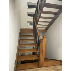 Drevené samonosné schody s čiernymi tyčkami